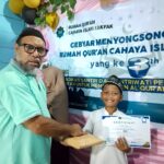 Ketua Yayasan Cahaya Islam Fakfak menyerahkan hadiah lomba dalam rangka Milad ke-3, Rumah Qur'an Cahaya Islam Fakfak