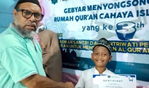 Ketua Yayasan Cahaya Islam Fakfak menyerahkan hadiah lomba dalam rangka Milad ke-3, Rumah Qur'an Cahaya Islam Fakfak