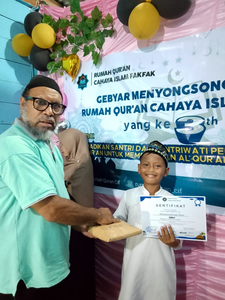 Ketua Yayasan Cahaya Islam Fakfak menyerahkan hadiah lomba dalam rangka Milad ke-3, Rumah Qur'an Cahaya Islam Fakfak