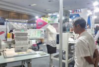 Seorang pria sedang memantau mesin bordir otomatis (foto : Jppn)