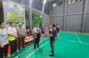 Ketua Panitia Liga Tomandin PBSI Ke-1 Tahun 2026, Rizal Ninggele, ST., menerima piala dari Ketua PBSI Kabupaten Fakfak, Widhi Asmoro Jati.
