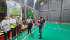 Ketua Panitia Liga Tomandin PBSI Ke-1 Tahun 2026, Rizal Ninggele, ST., menerima piala dari Ketua PBSI Kabupaten Fakfak, Widhi Asmoro Jati.