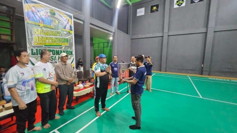 Ketua Panitia Liga Tomandin PBSI Ke-1 Tahun 2026, Rizal Ninggele, ST., menerima piala dari Ketua PBSI Kabupaten Fakfak, Widhi Asmoro Jati.